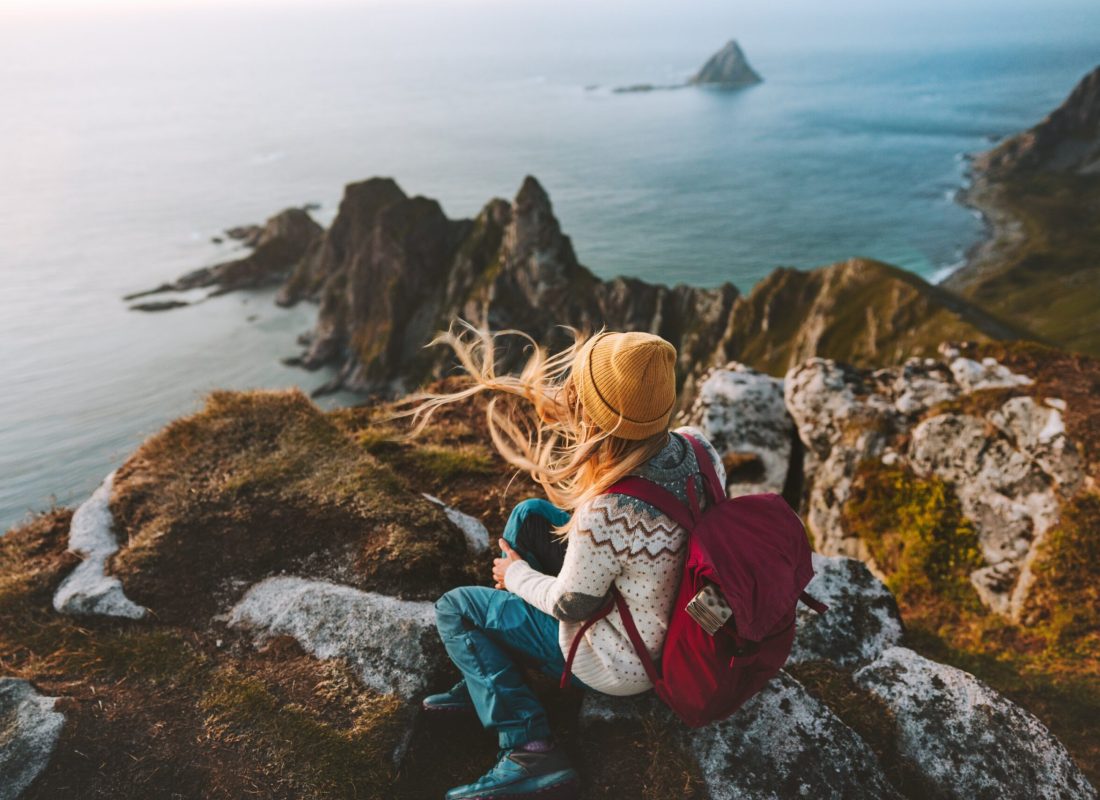 Woman relaxing alone travel in Norway adventure vacations healthy lifestyle backpacking Vesteralen landscape rocks and sea aerial view